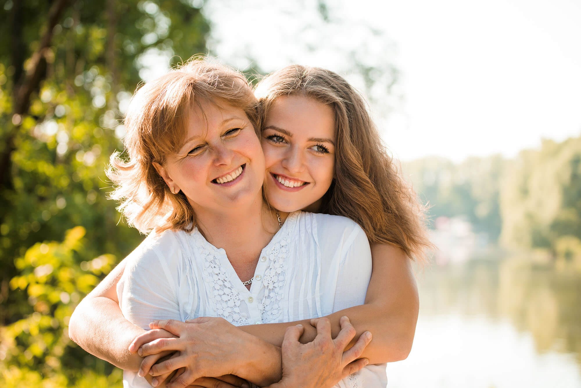 A mother and daughter hug and smile because they are happy with the treatment they received at G Orthodontics