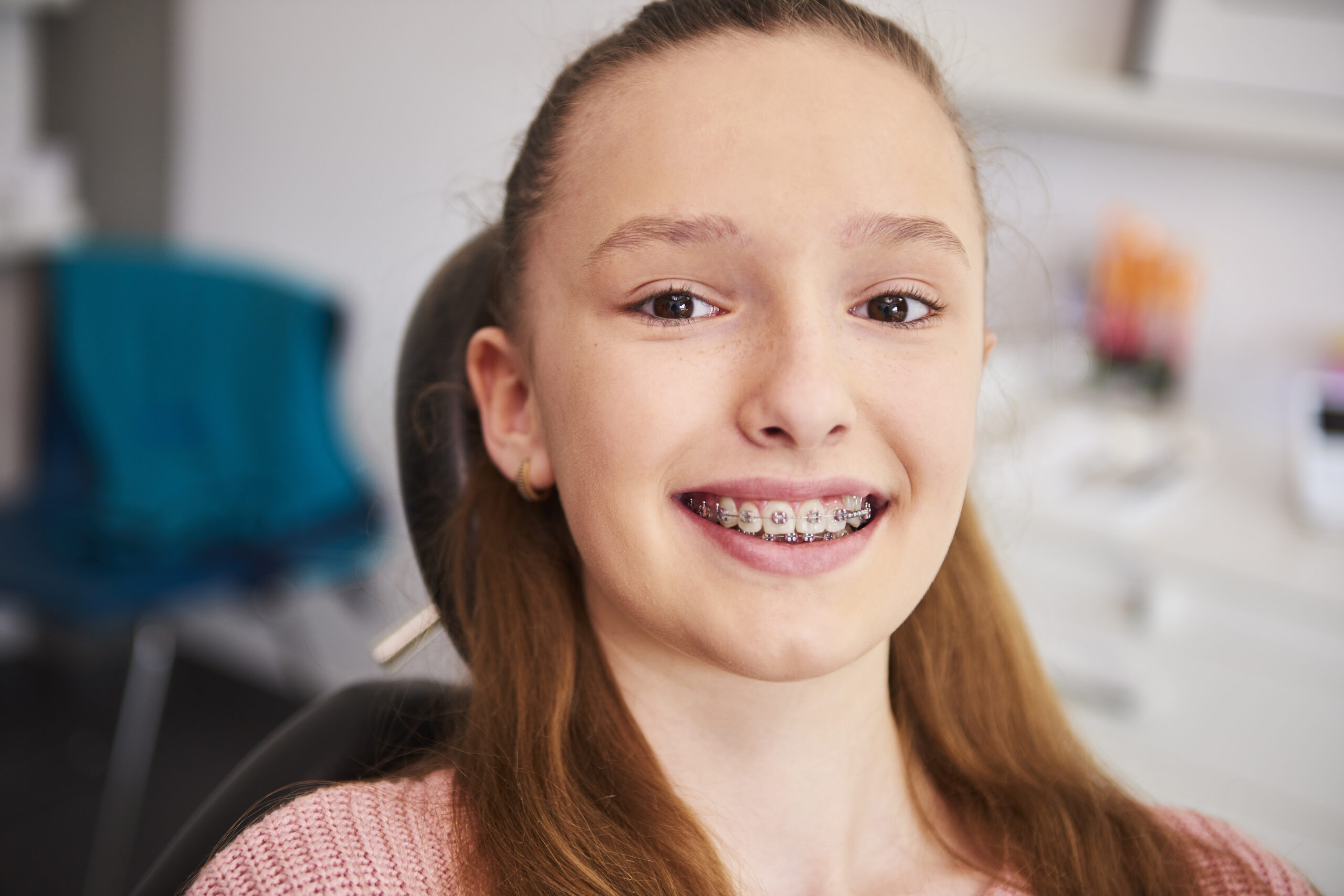 Portrait of smiling child with braces in dentist’s office