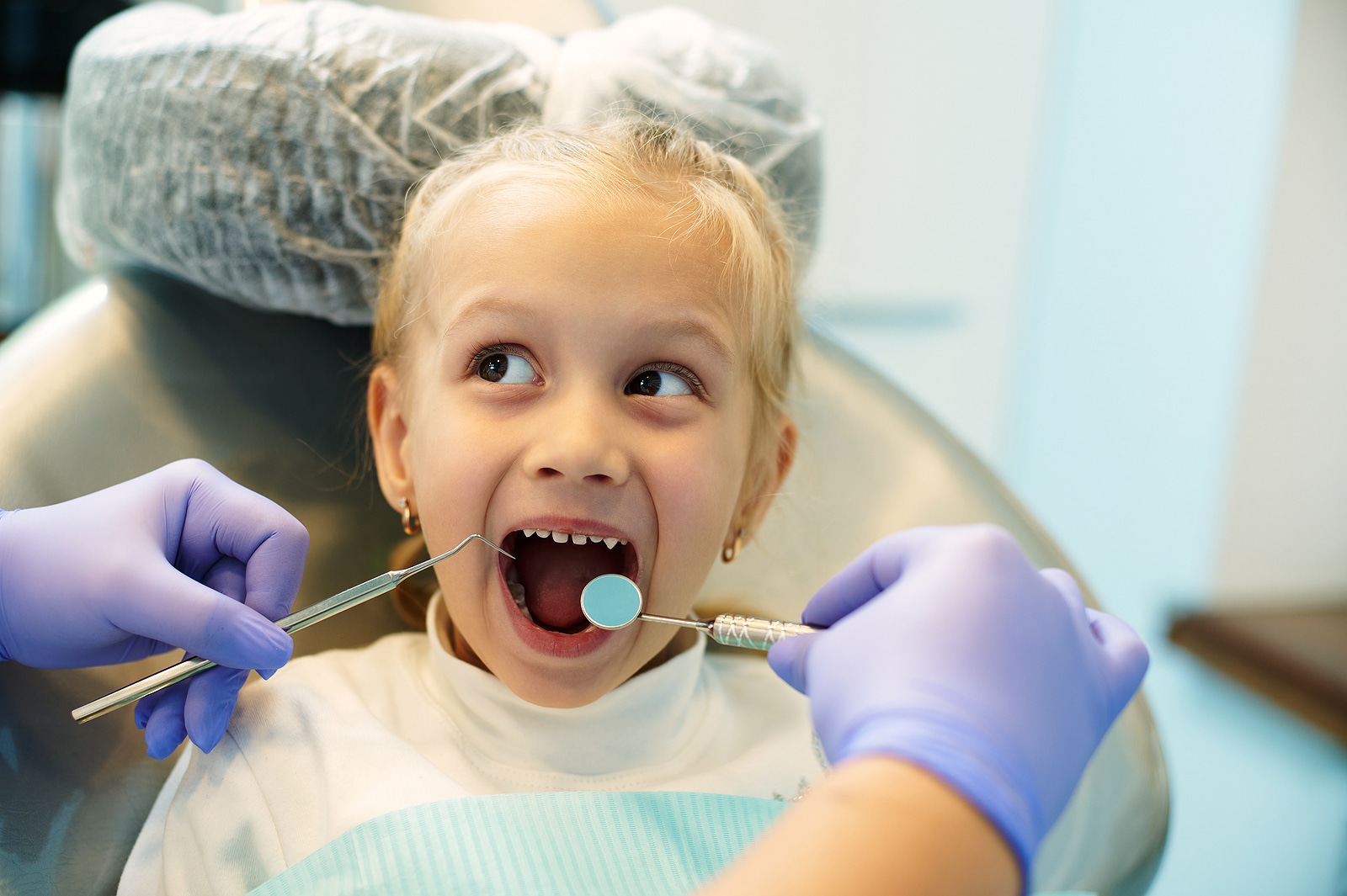Child sitting in dental chair during early orthodontic treatment evaluation